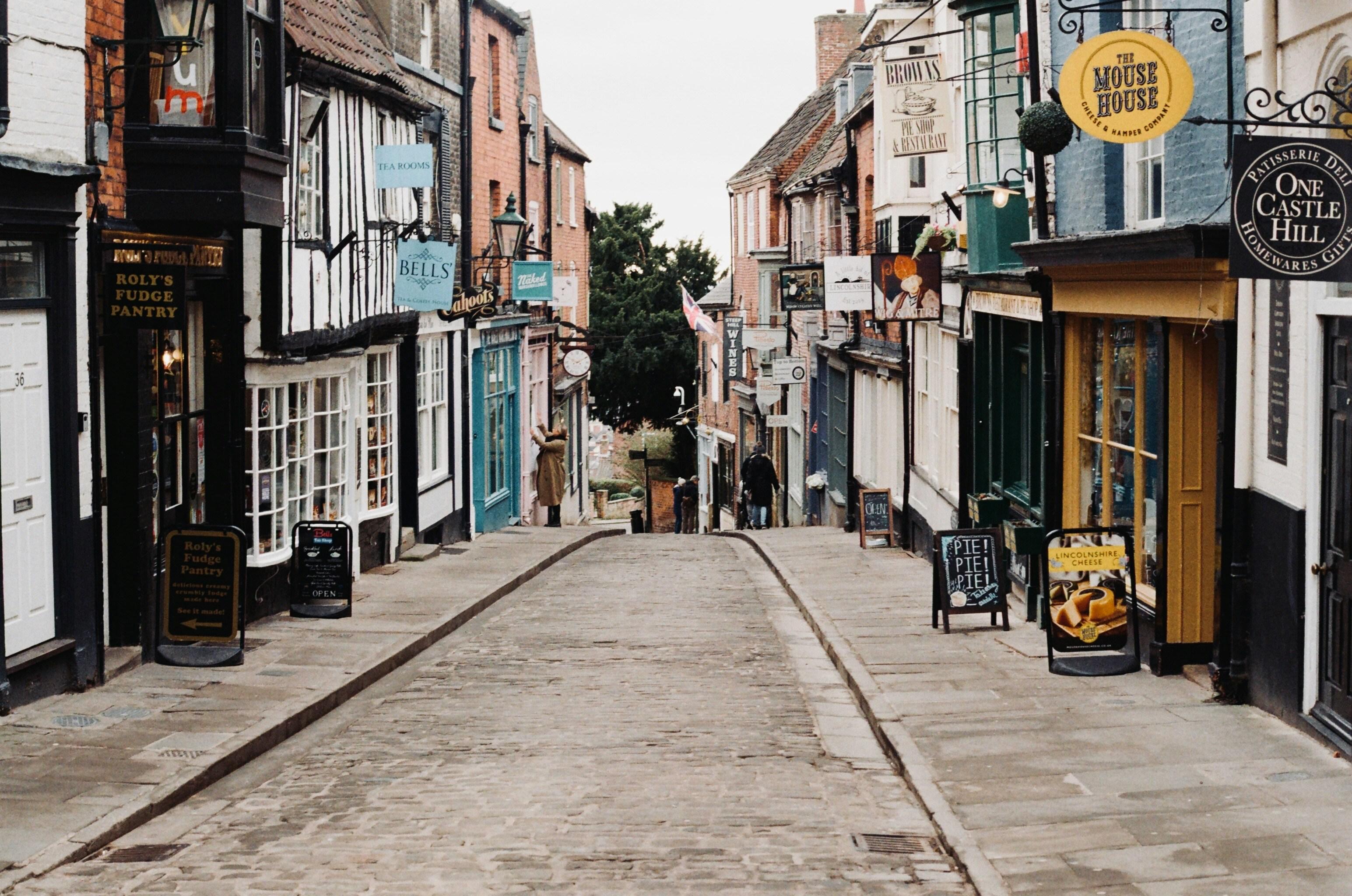Steep Hill shows a cobbled street with independent shops on both sides of the road