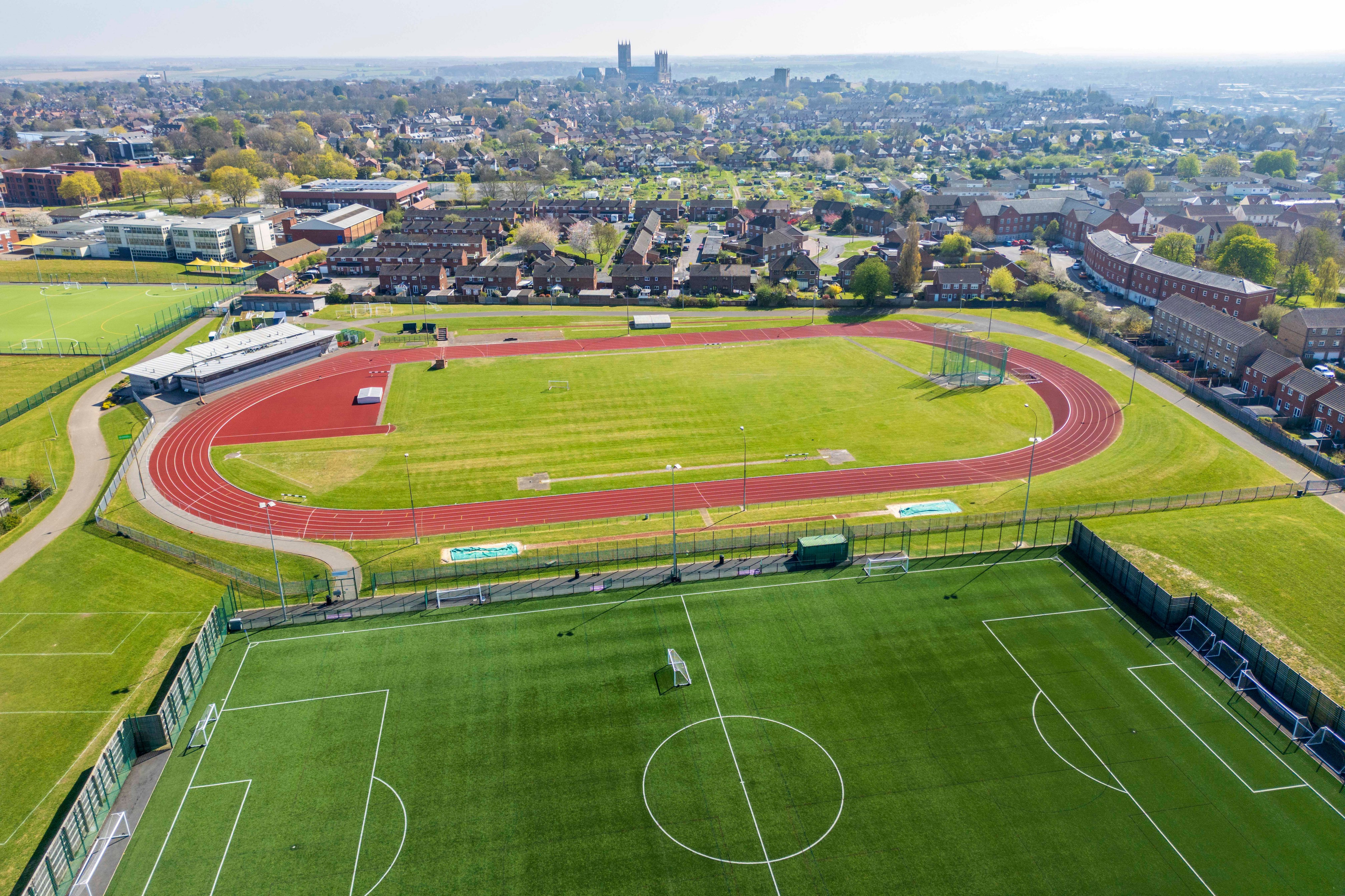 A drone shot looking down on an oval racetrack and full-sized football pitch behind Yarborough Leisure Centre.