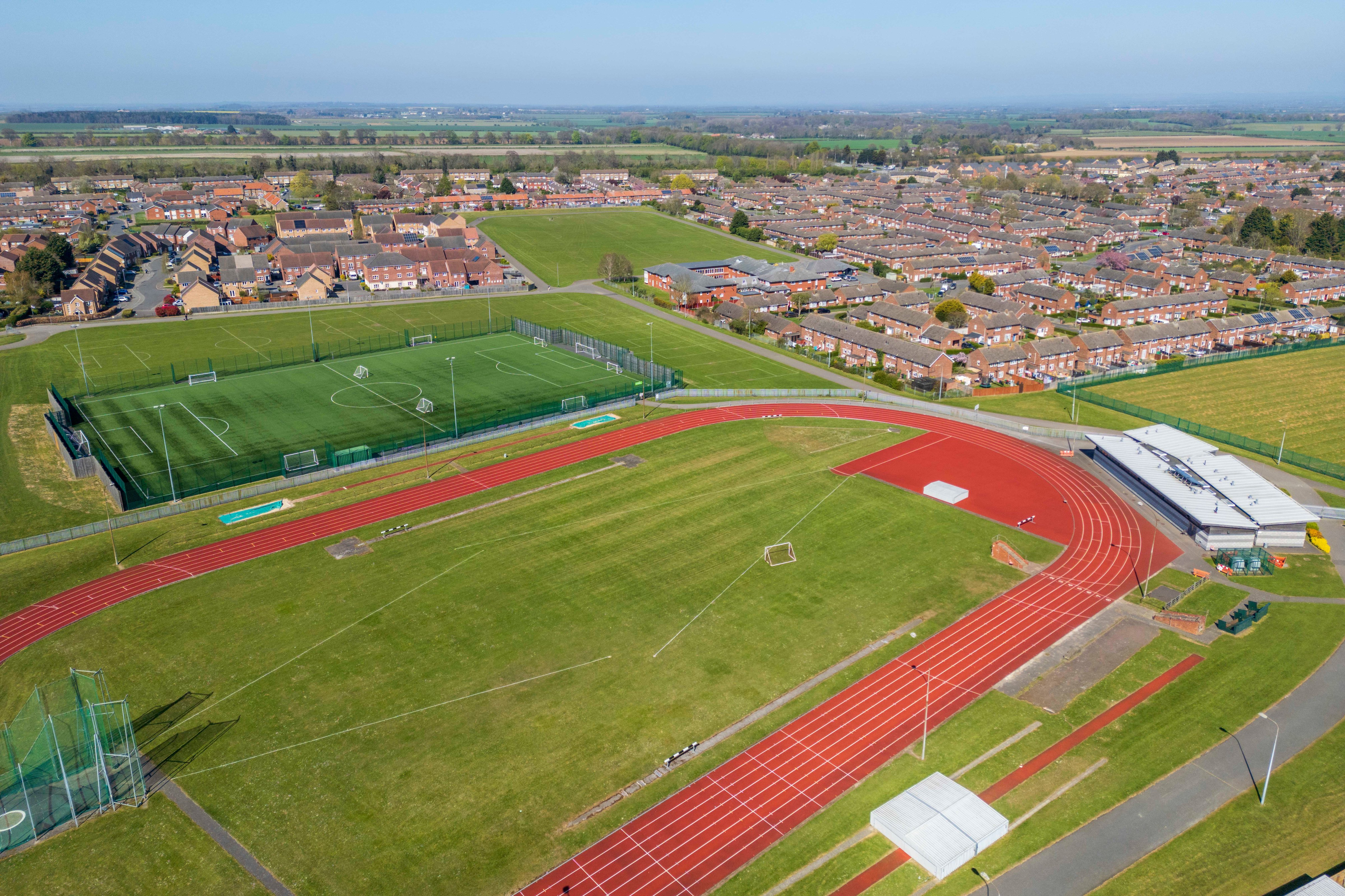 A drone shot looking down on a racetrack and full-sized football pitch behind Yarborough Leisure Centre.