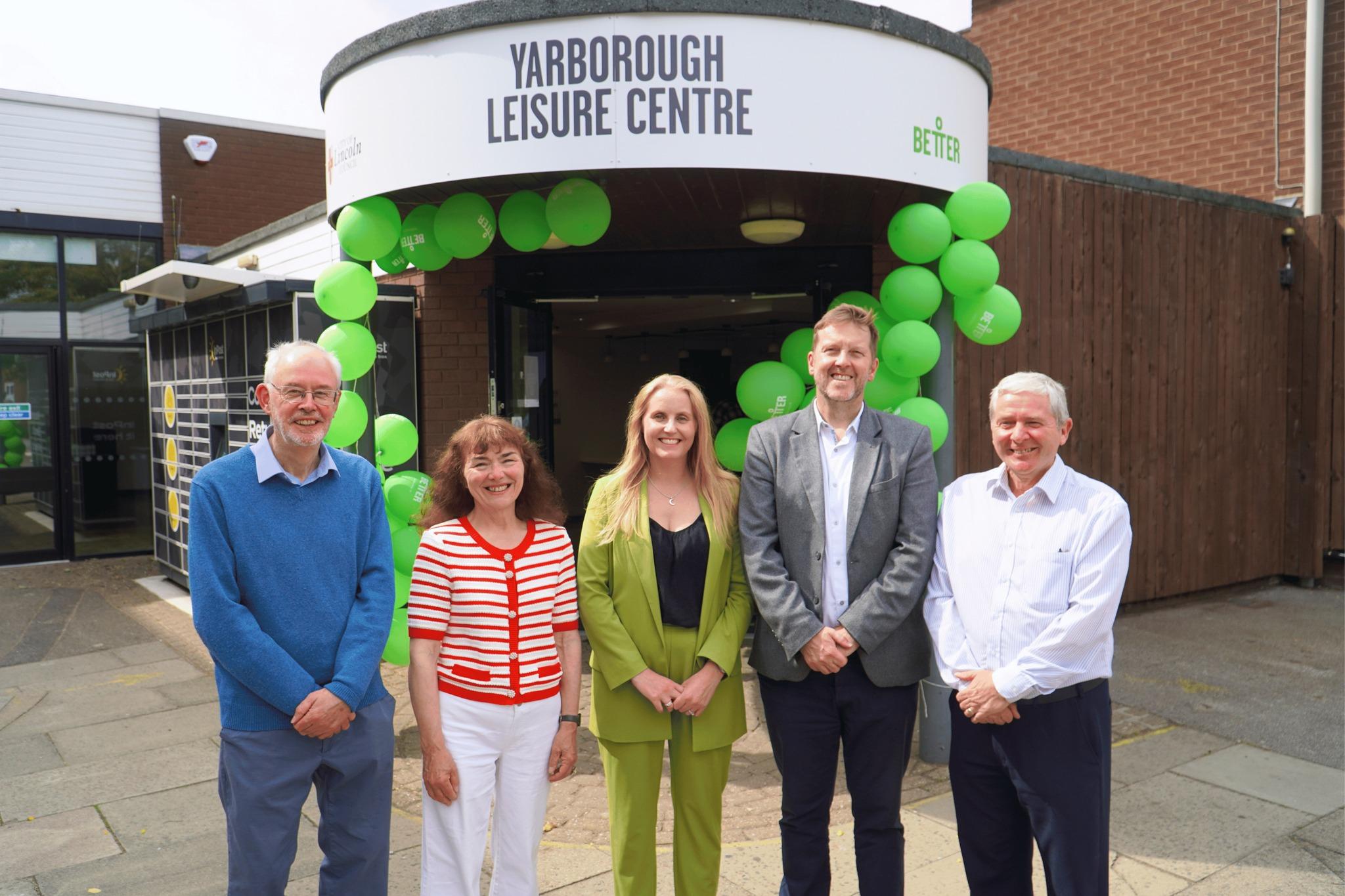 From left to right a man, two women, and two men stood in a row in front of the Yarborough Leisure Centre entrance, which has been decorated with green balloons.
