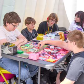 A group of children sit around a table in the Zone Go, playing Dungeons and Dragons.