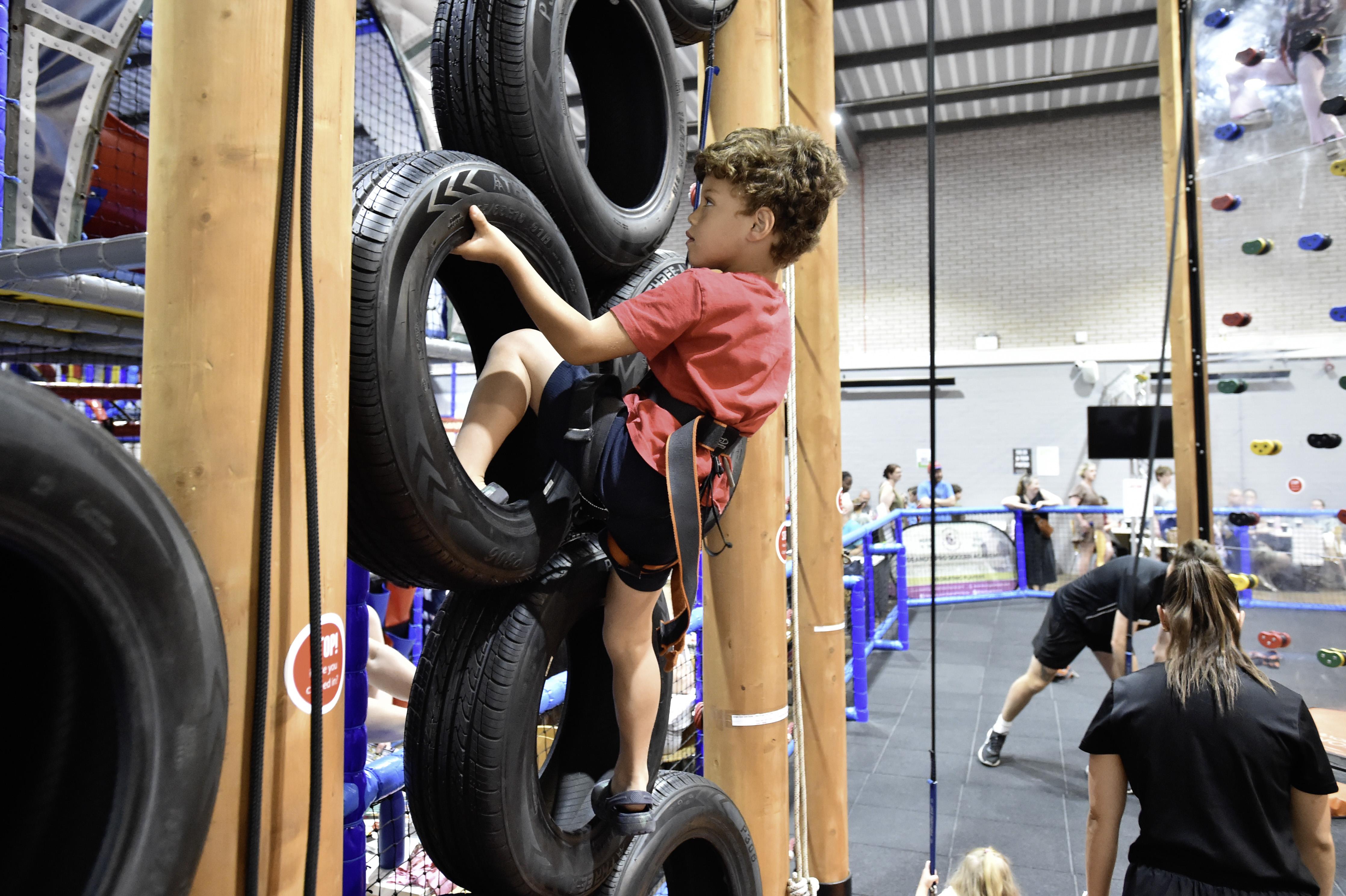 A young child playing on the climbing frame made of tyres in Birchwood Leisure Centre.