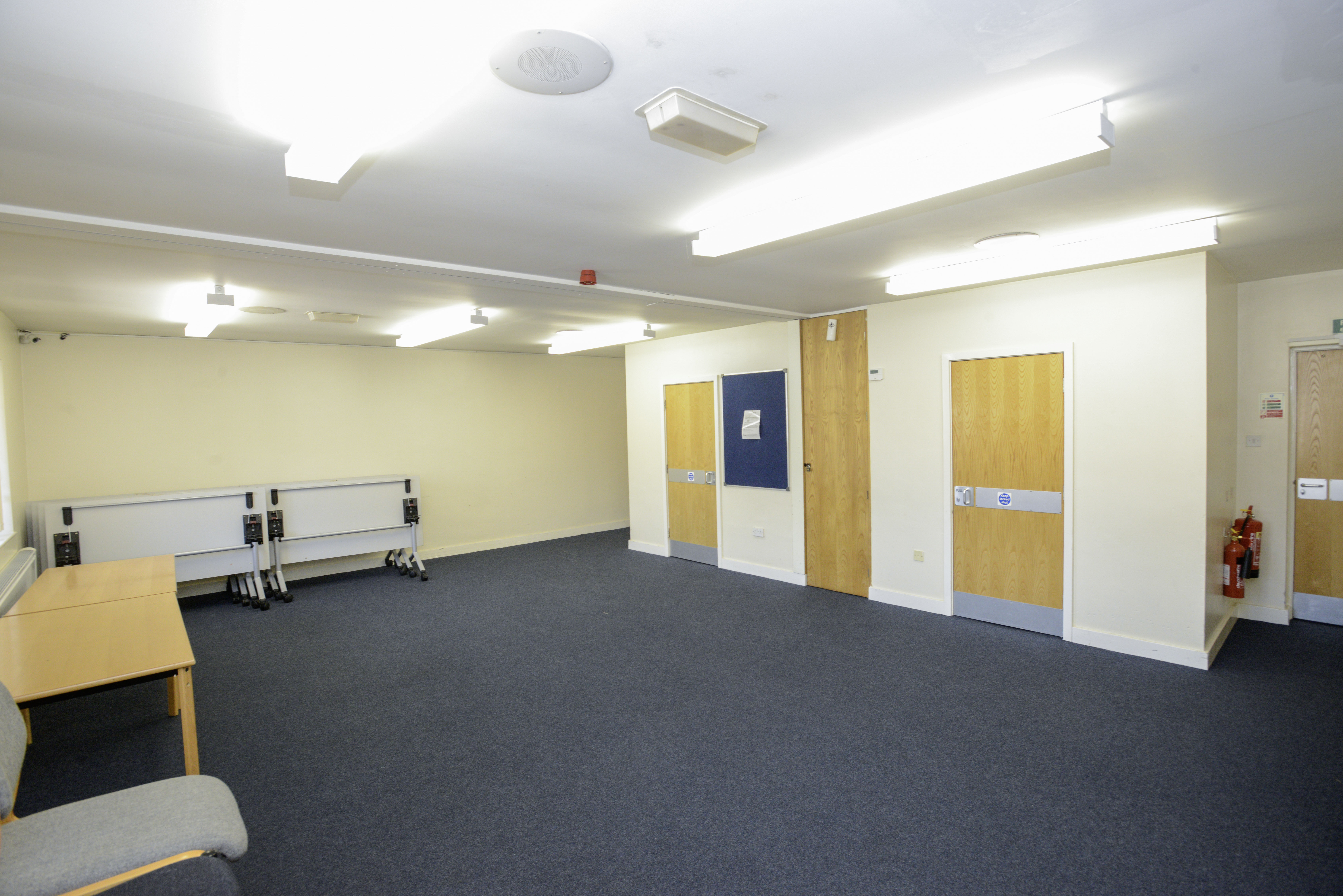 Carpeted room, with tables around the edge 