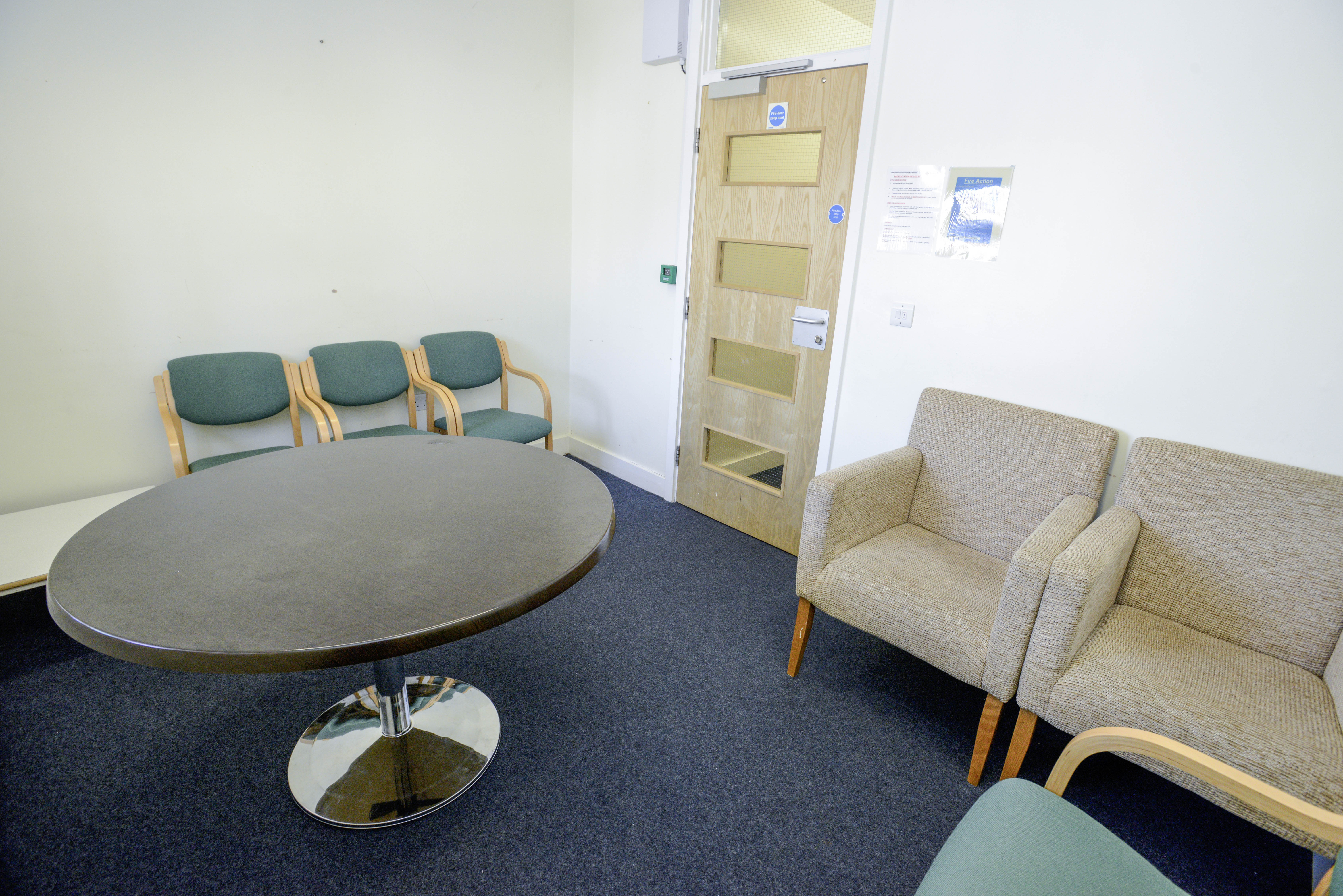 Carpeted room containing a round table and chairs
