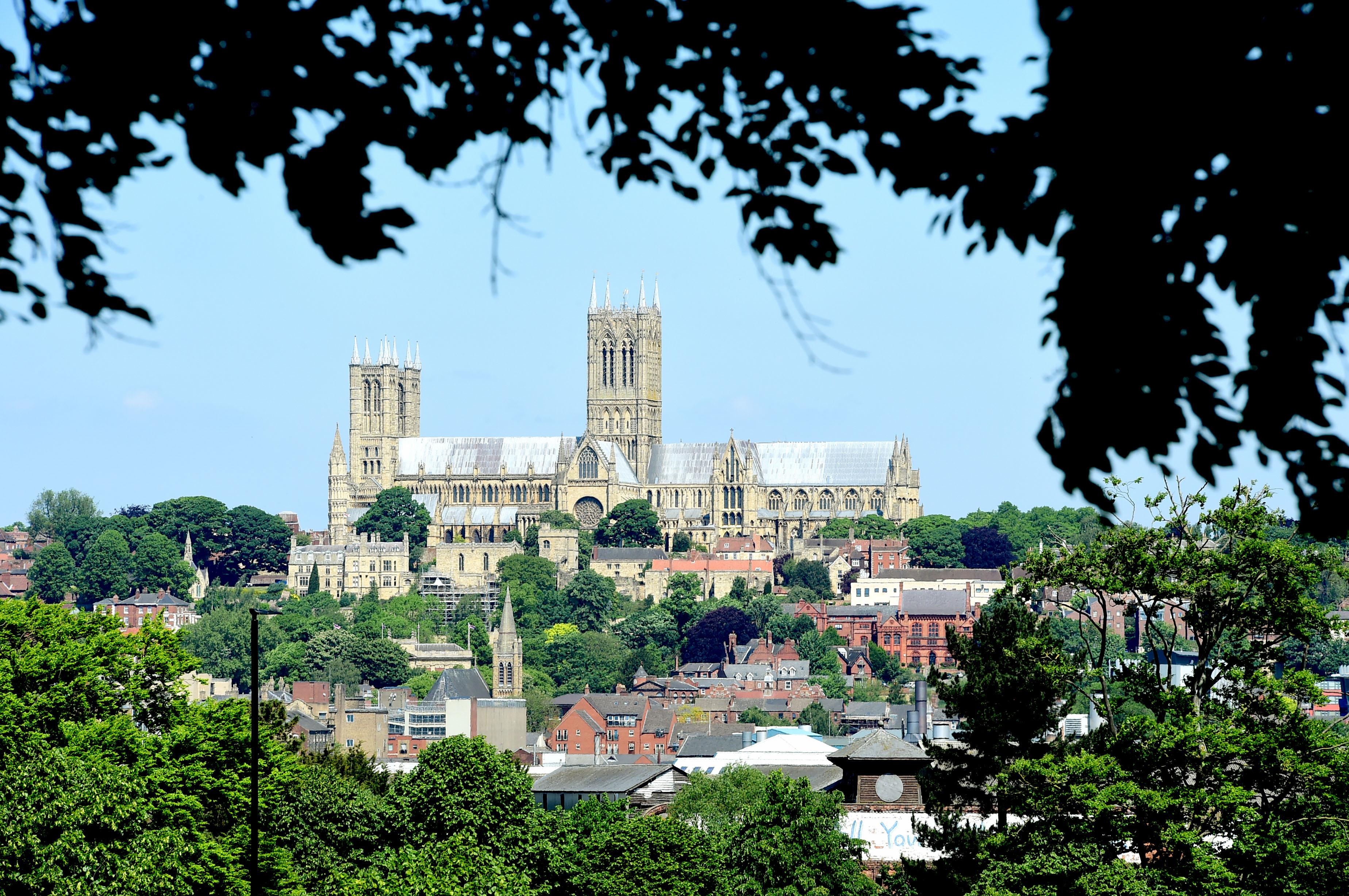 Lincoln Cathedral in the distance on a blue sunny day. The photo has been taken from downhill Lincoln.