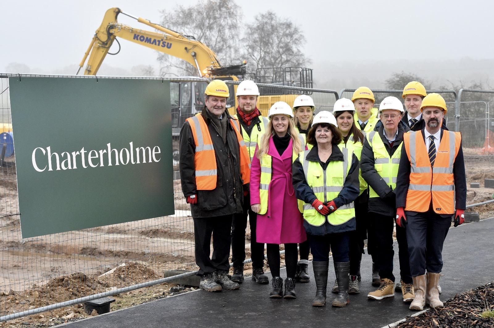 All of the main stakeholders stood in front of the new Charterholme logo on the site development.
