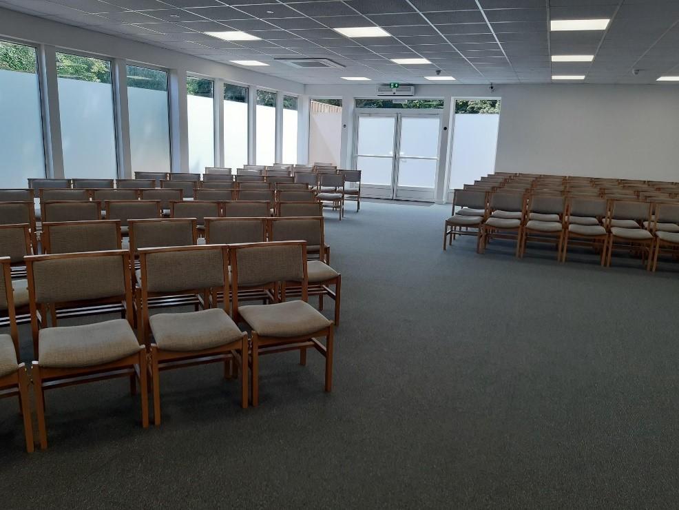 Chapel room showing the exit and rows of chairs