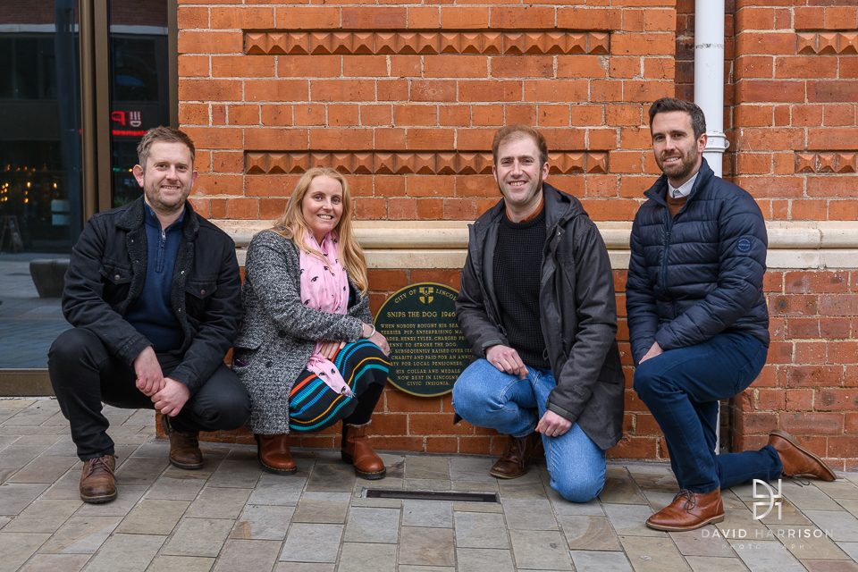 Representatives gather around the Snips the dog plaque