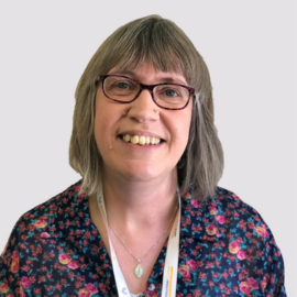 Dianne Slapp wears a floral shirt and smiles at the camera.