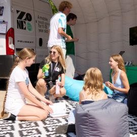 A group of young people at Zone Go sat on bean bags chatting and drawing.