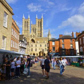 The Farmers Market in Castle Square, with Lincoln Cathedral in the background against a blue sky.