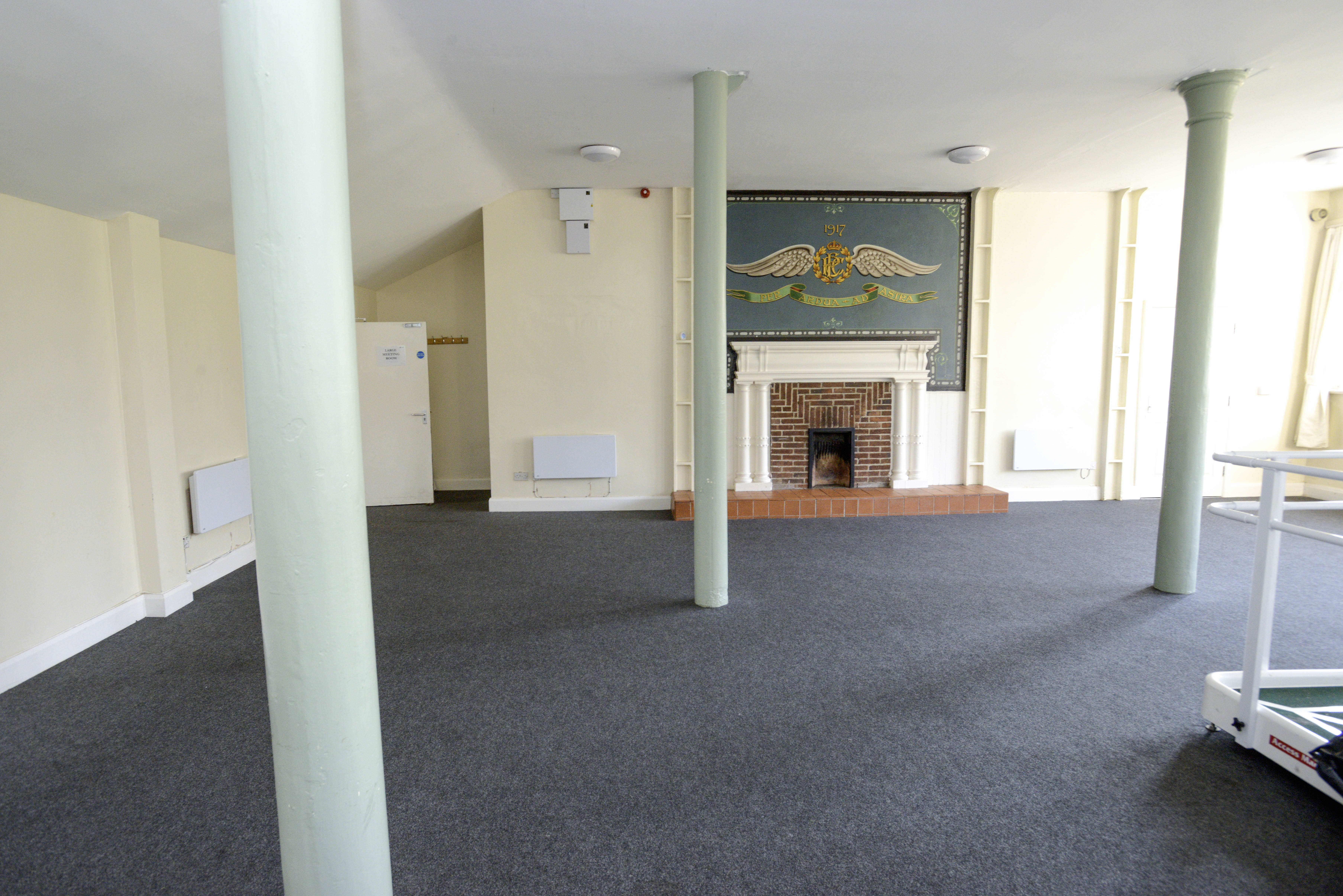 Carpeted room, with pillars, and RAF mural on wall, above fire place