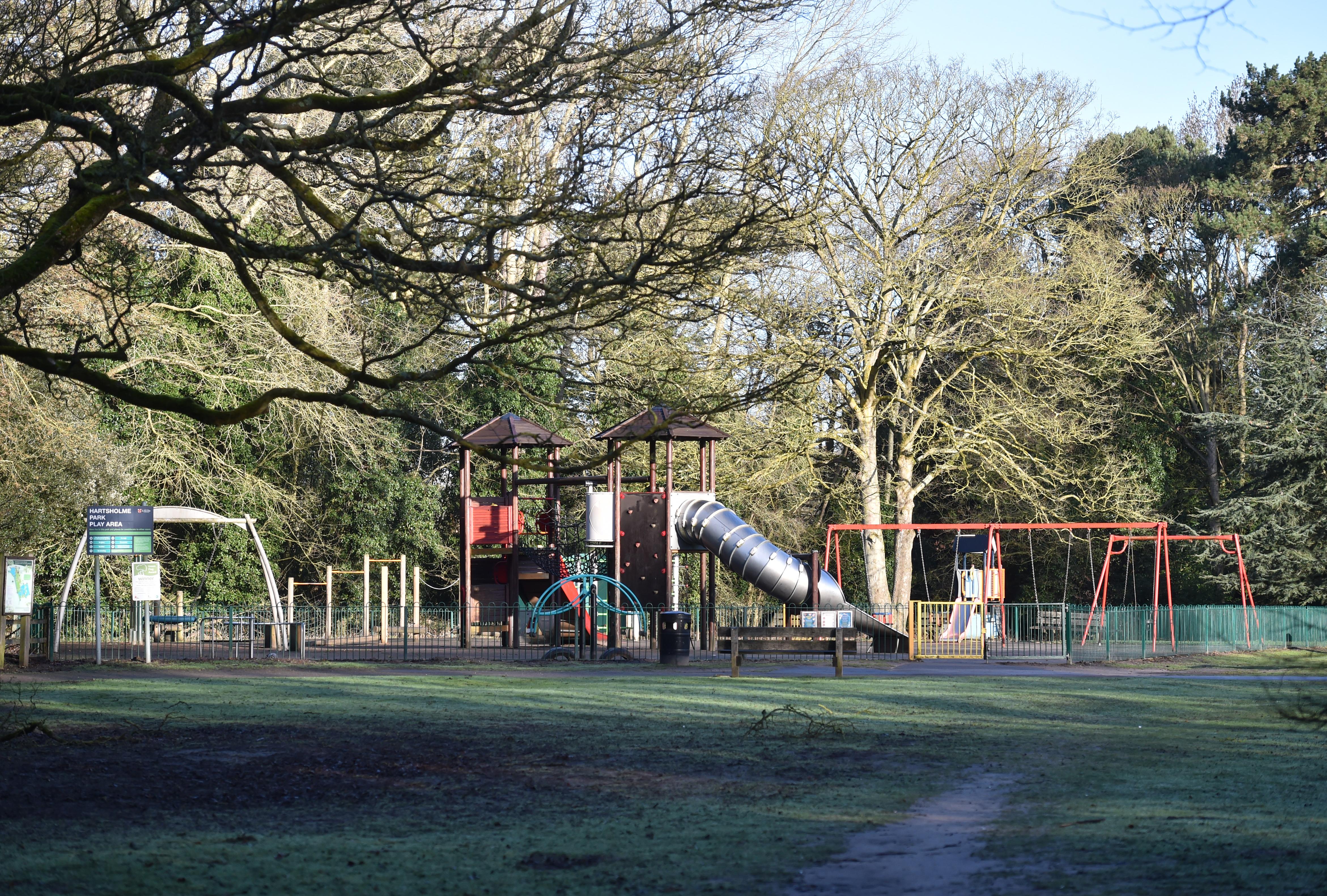 A children's outdoor play area with climbing frames and metal tube slides.