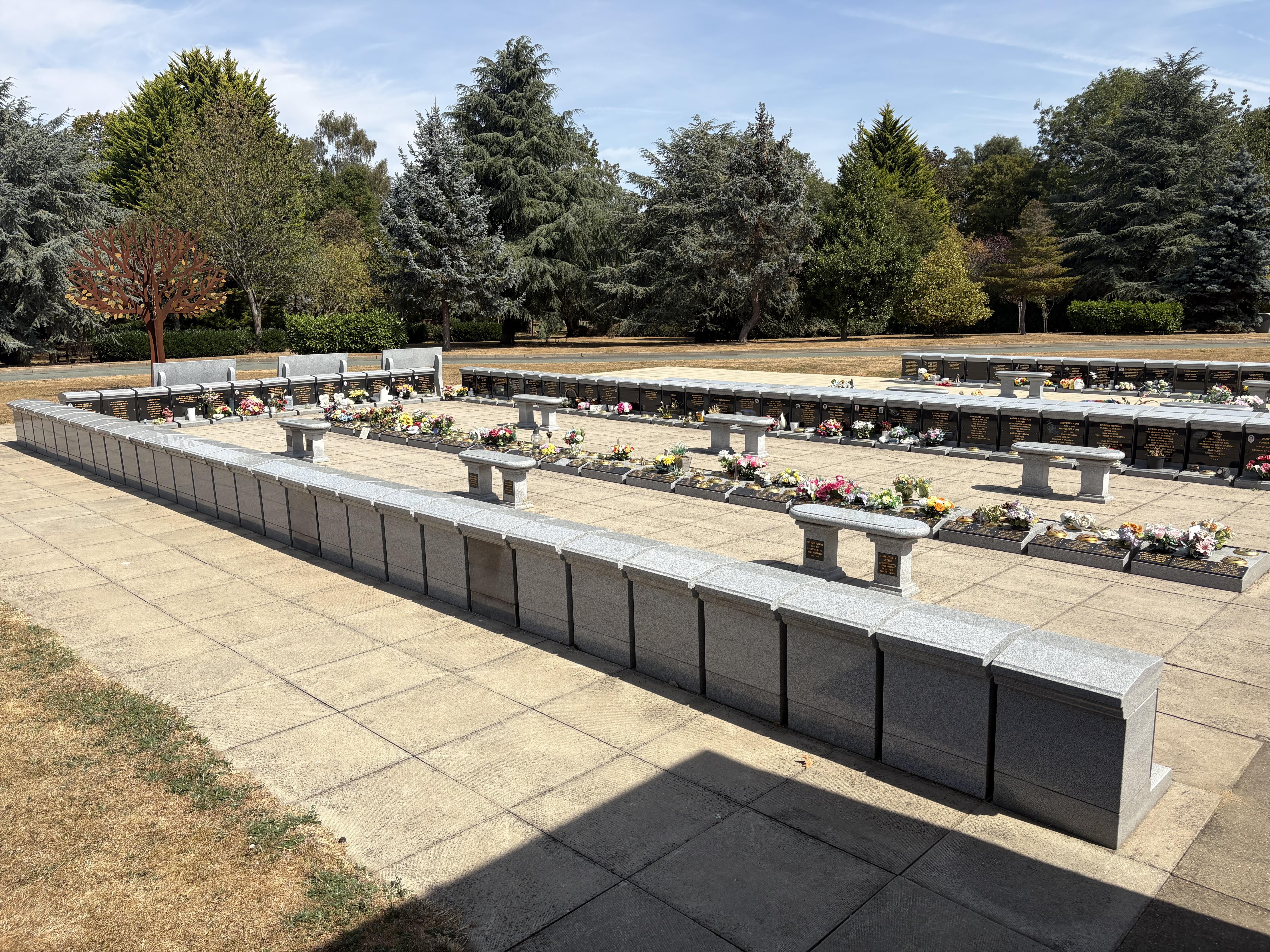 A neatly arranged memorial garden with many slabs and headstones.