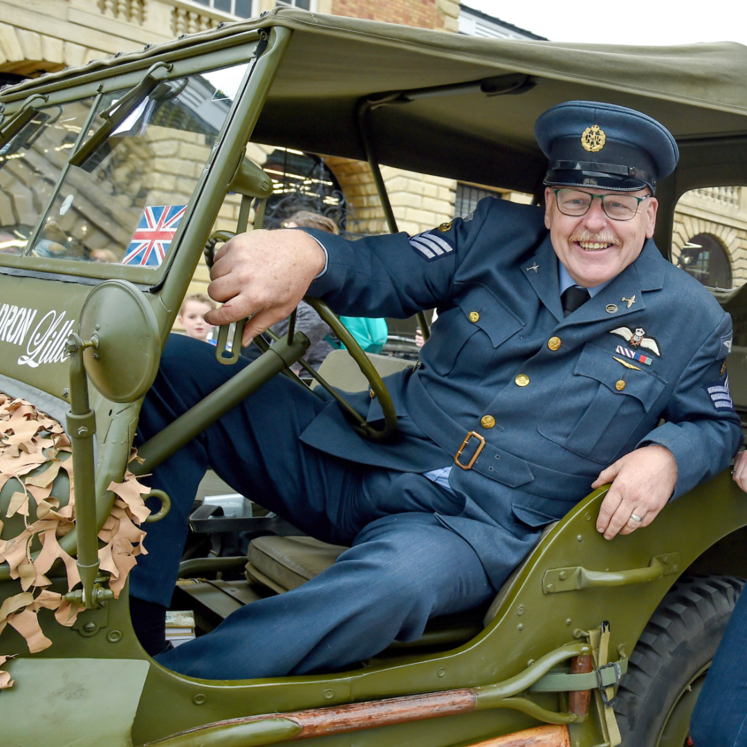 A veteran poses in a military vehicle outside Cornhill Market.