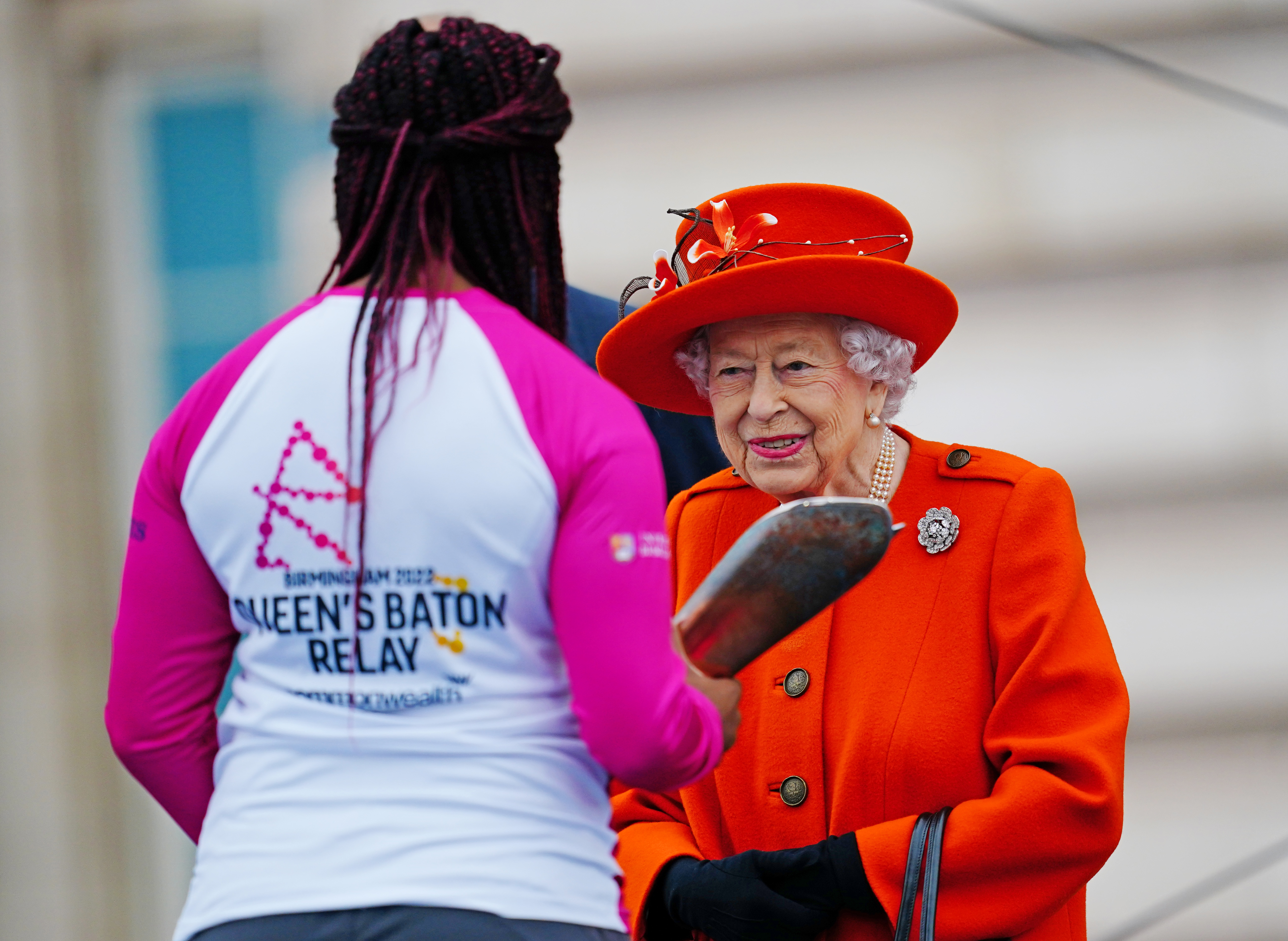 The Queen alongside the Queen's Baton