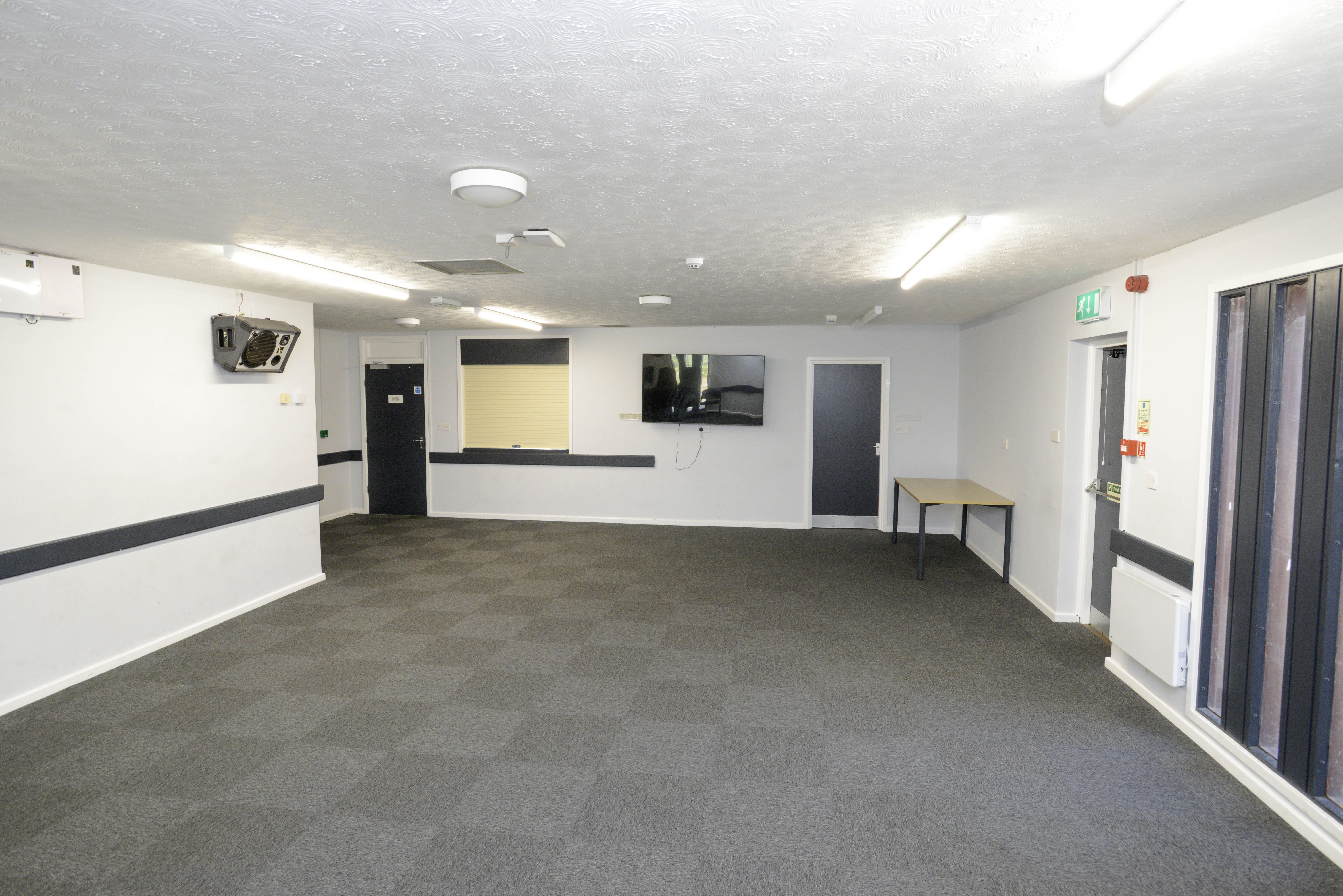Carpeted Room, hatch to kitchen, monitor on wall