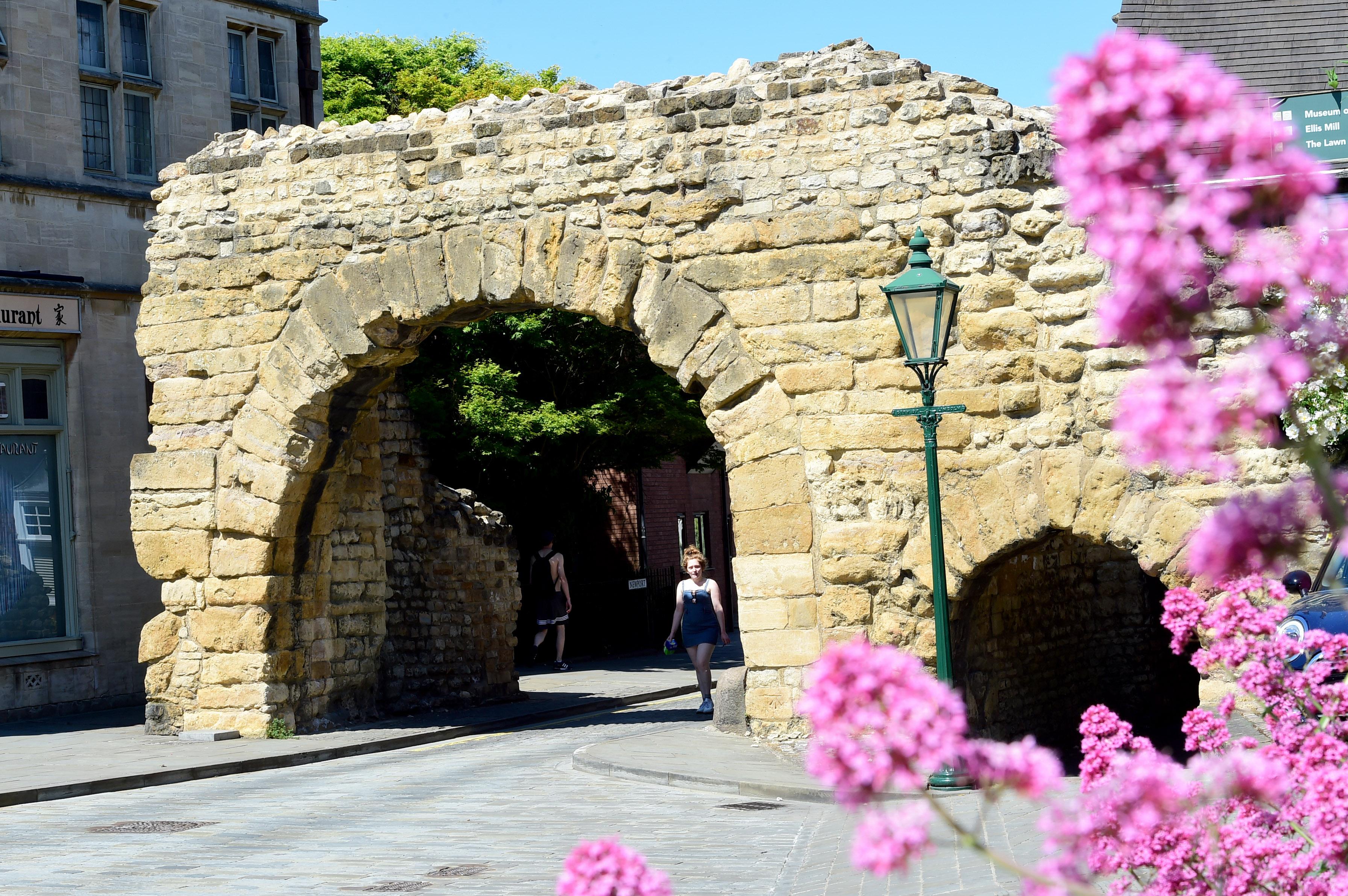 An old Roman stone archway, there is a bigger taller arch net to a smaller arch.