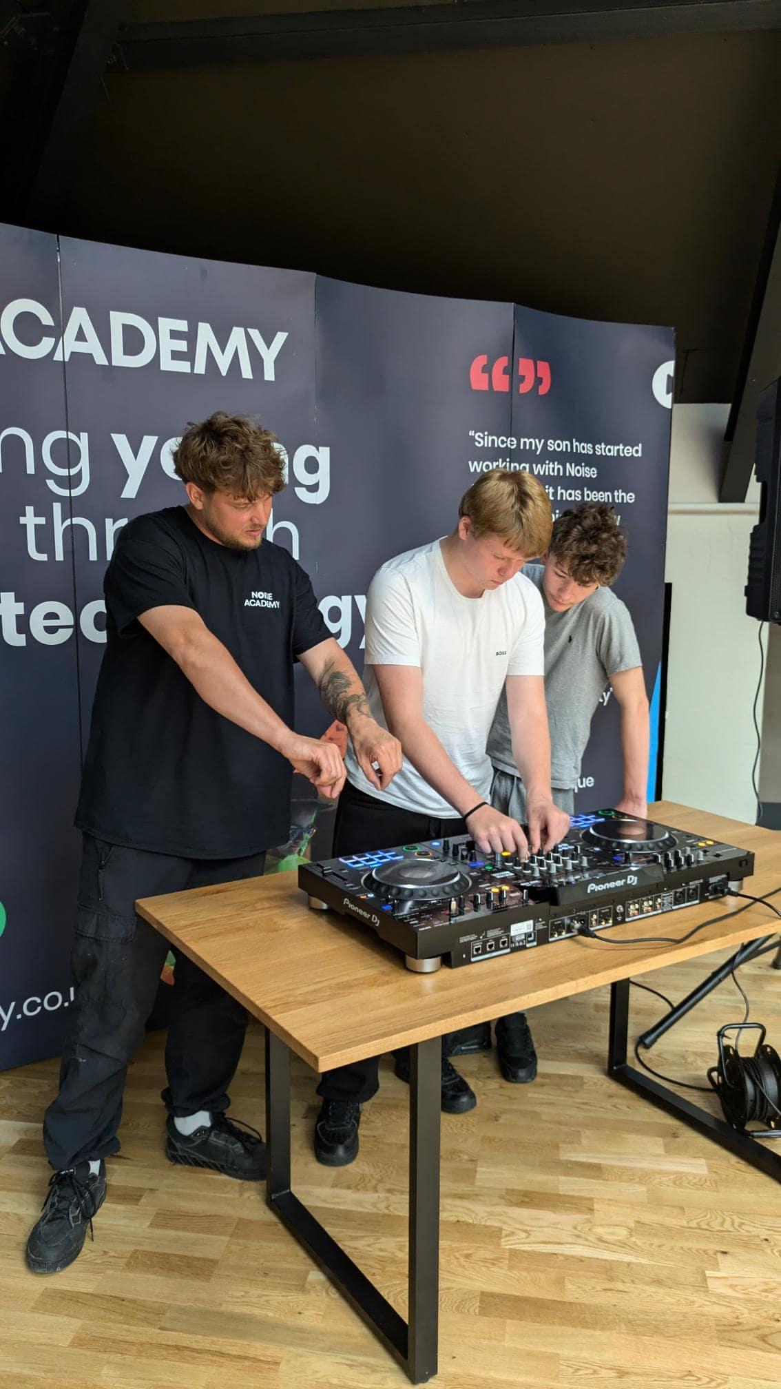 Joe from Noise Academy teaches two young people how to DJ in a workshop