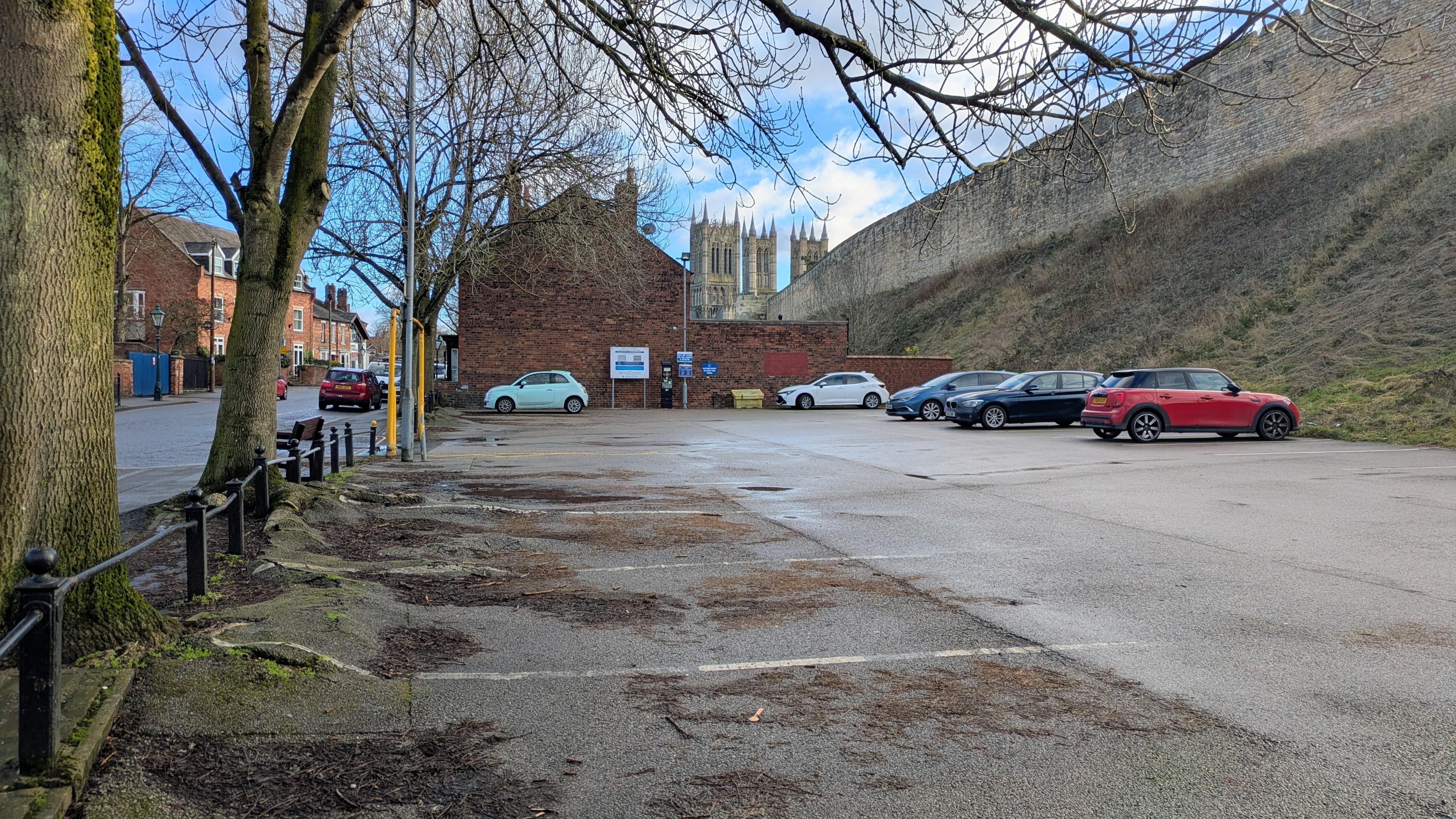 A mostly empty car park in uphill Lincoln with Lincoln Cathedral in the background.