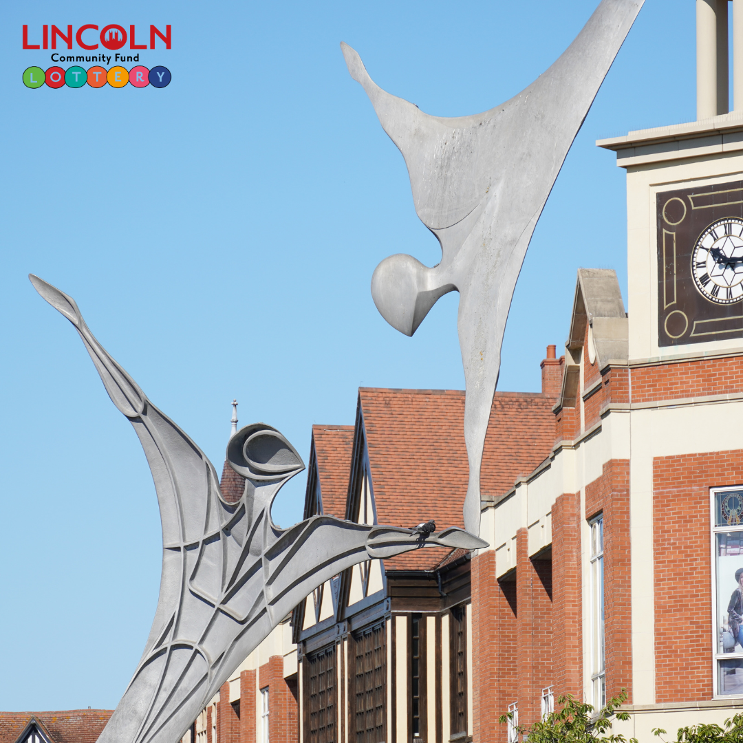 A photo of a metal statue on city square.