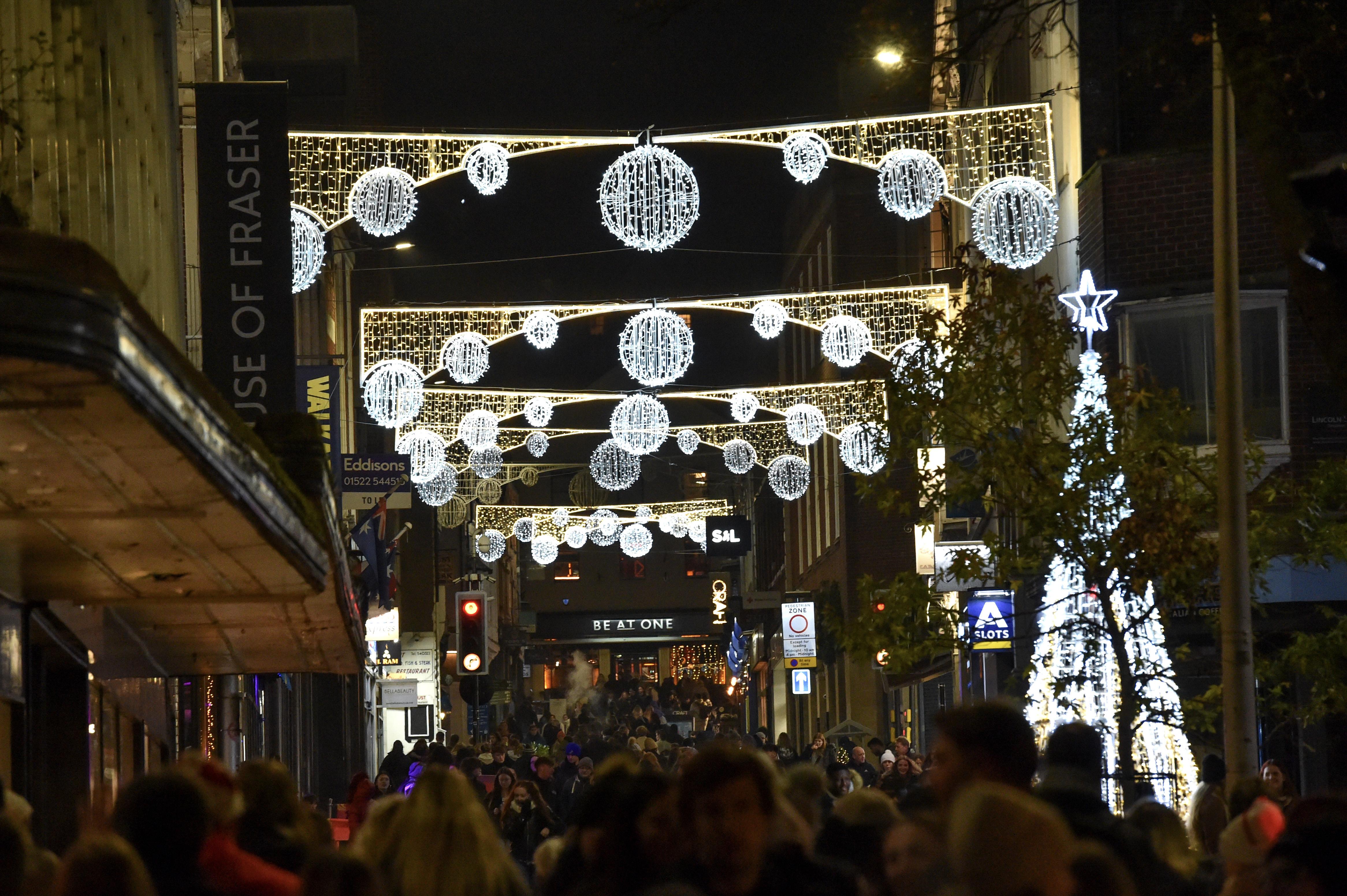 Christmas lights over Lincoln High Street lit up on a dark night.