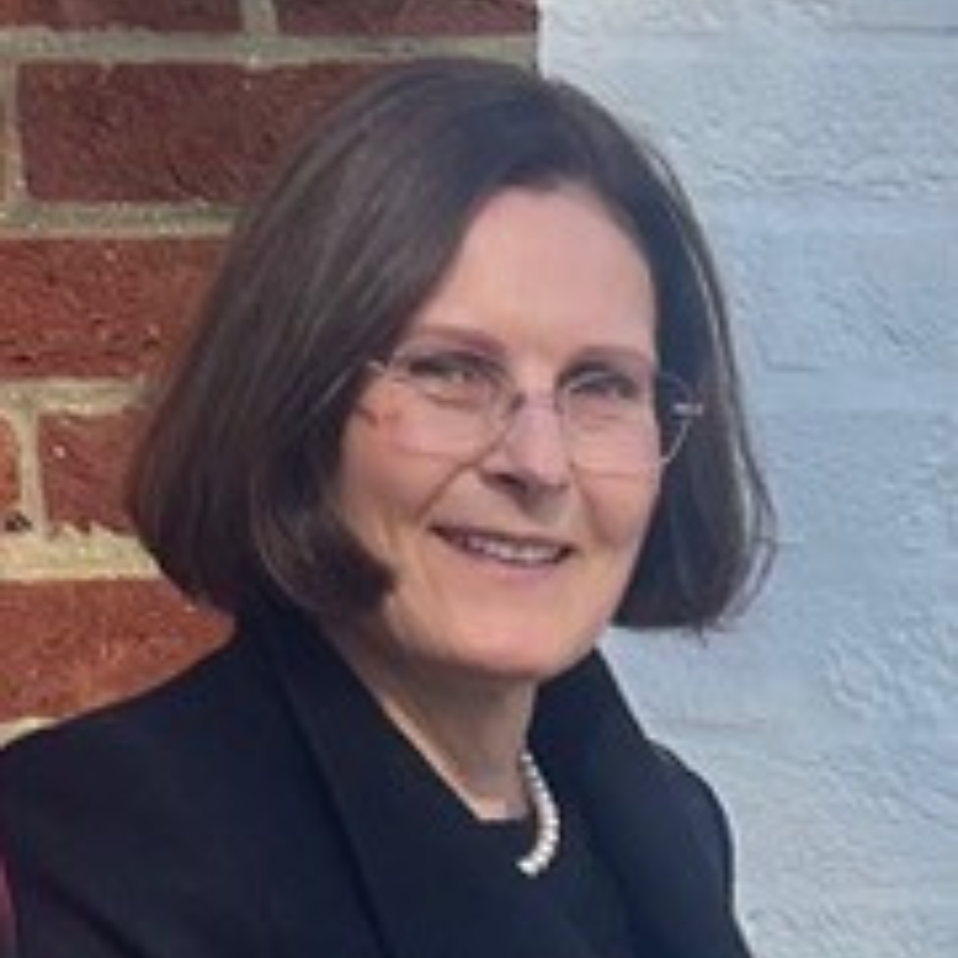 Ursula Bidletter smiles for a headshot photo outside wearing a dark coat.