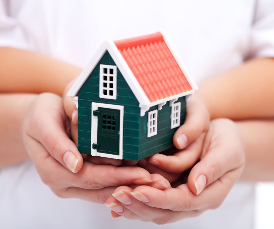 image shows a small home being held in some peoples hands