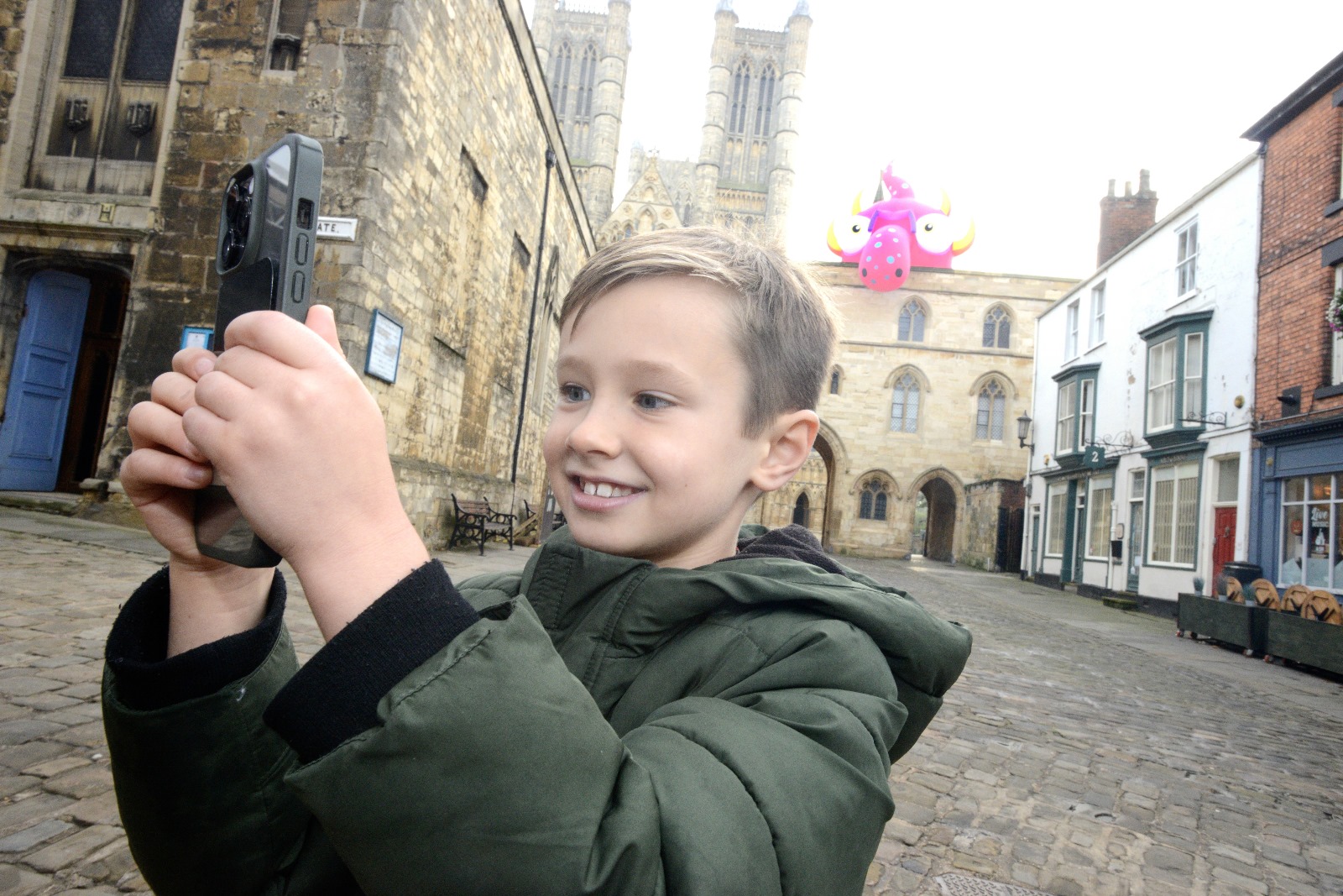 image shows a young boy in front of one of the monsters by the cathedral