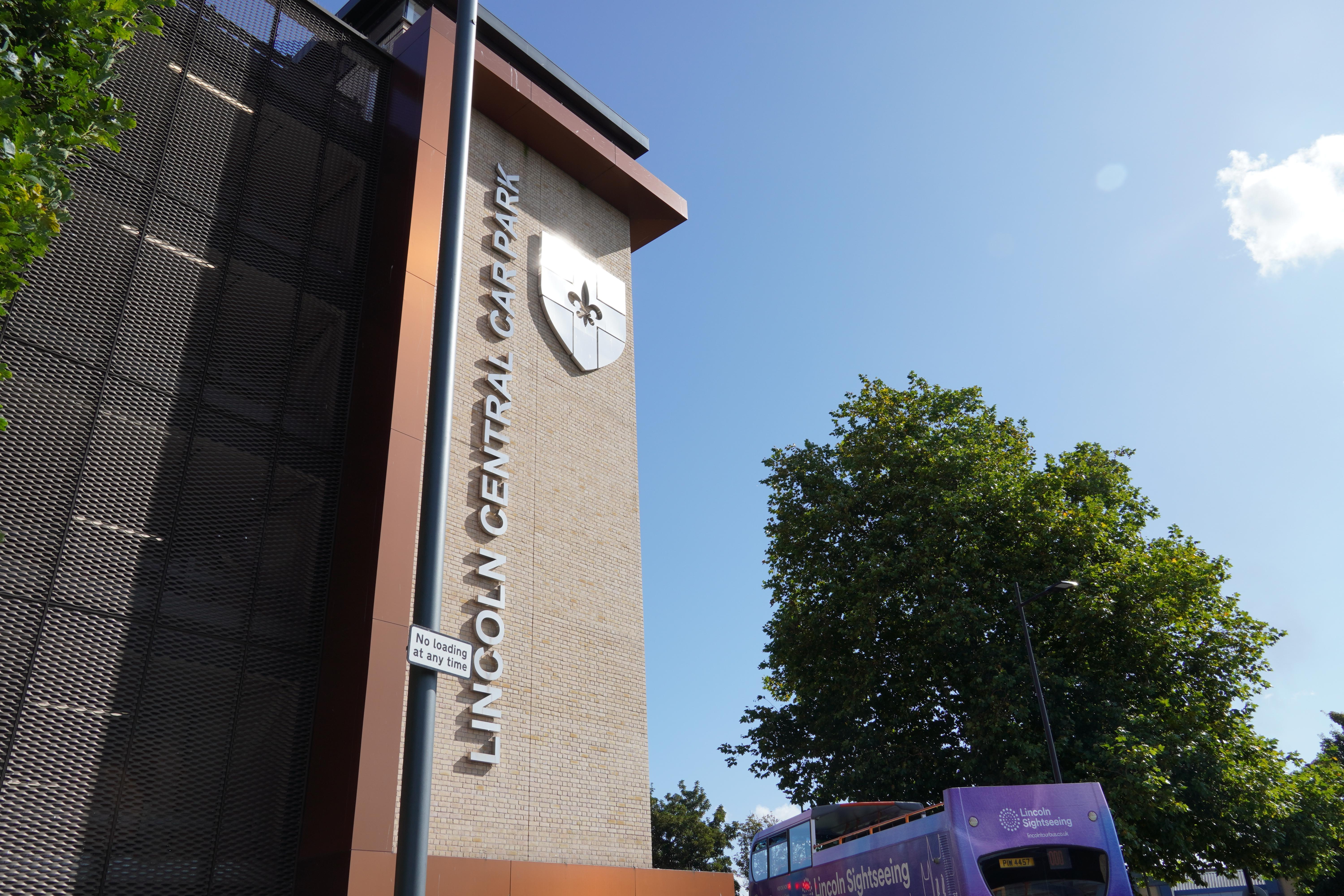 A picture of the outside of Lincoln Central Car Park, a tall multi-storey building with Lincoln Central Car Park in silver letters and the Lincoln flag on the front of the building.