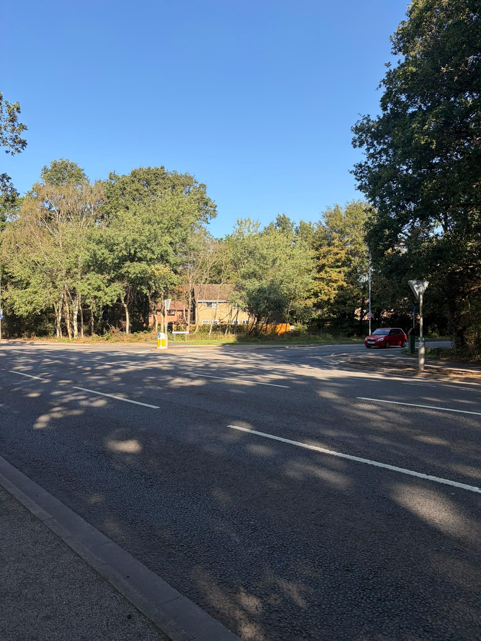 A car driving up to a junction leading on to a main road from a side road.